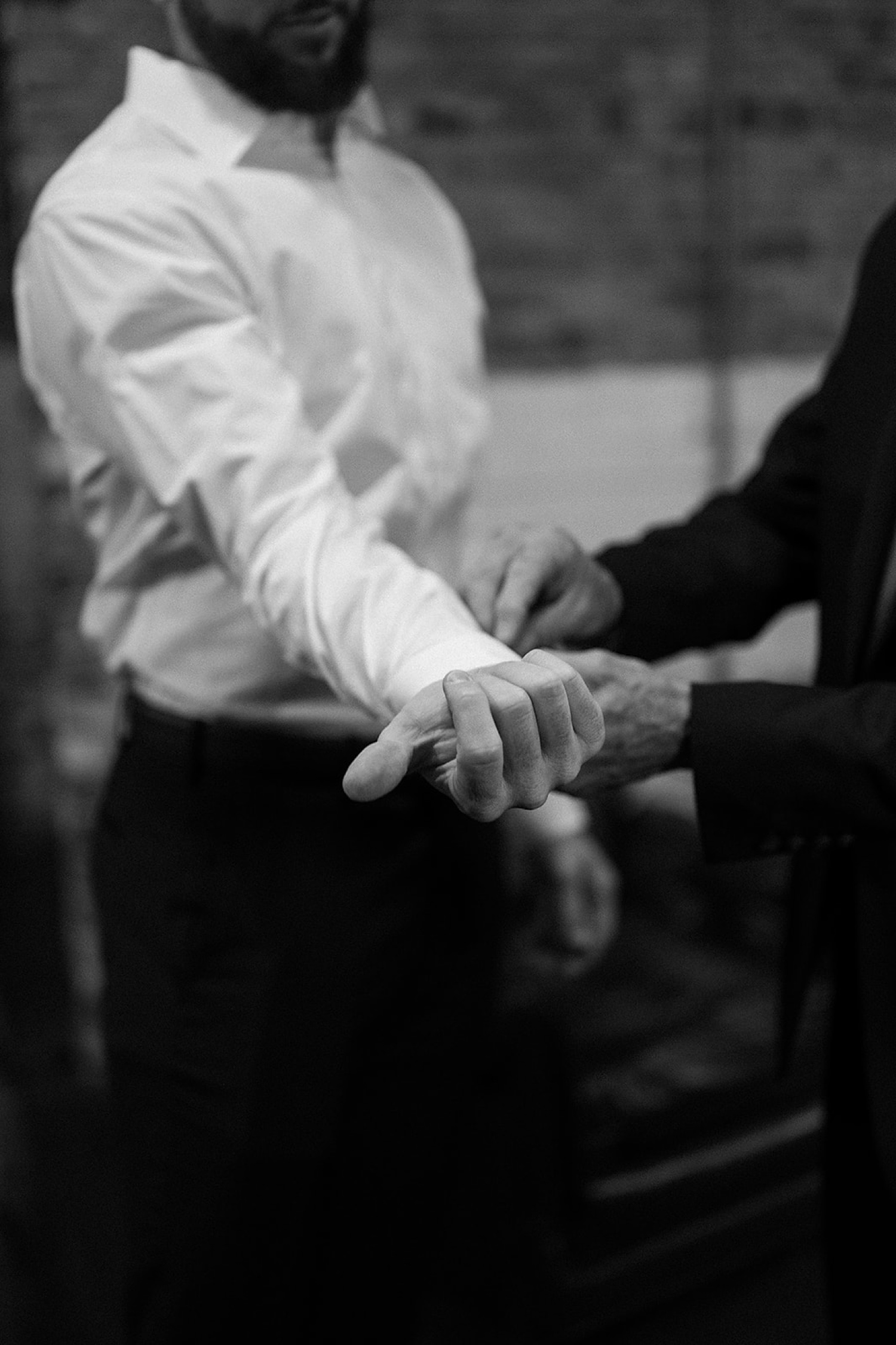 A groom getting his cuff links put on