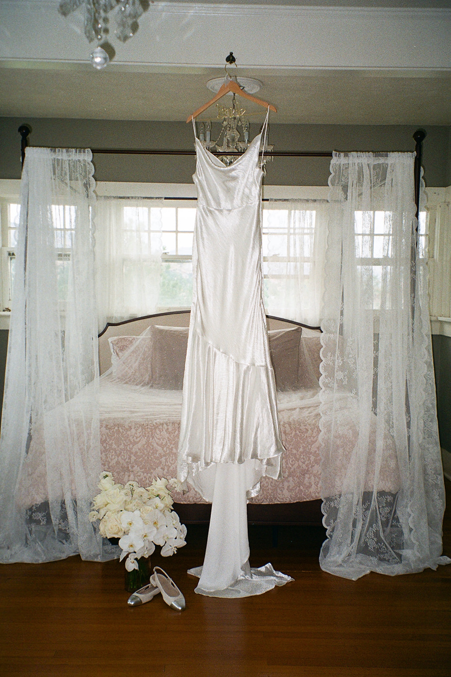 A film photo of a wedding dress hanging up at The Manor House wedding venue in Littleton, Colorado