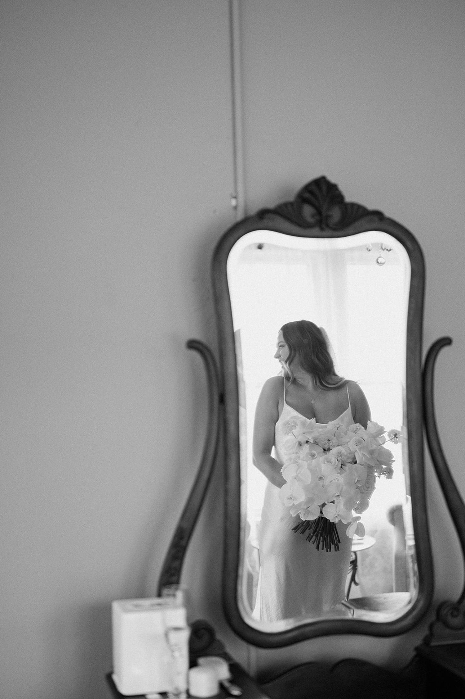 A photo of a bride looking over her shoulder, photographed through a mirror's reflection