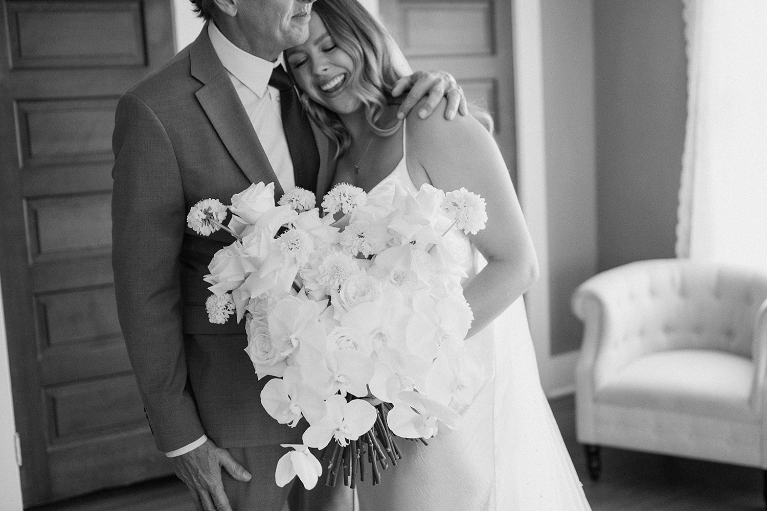 A bride hugging her father and smiling