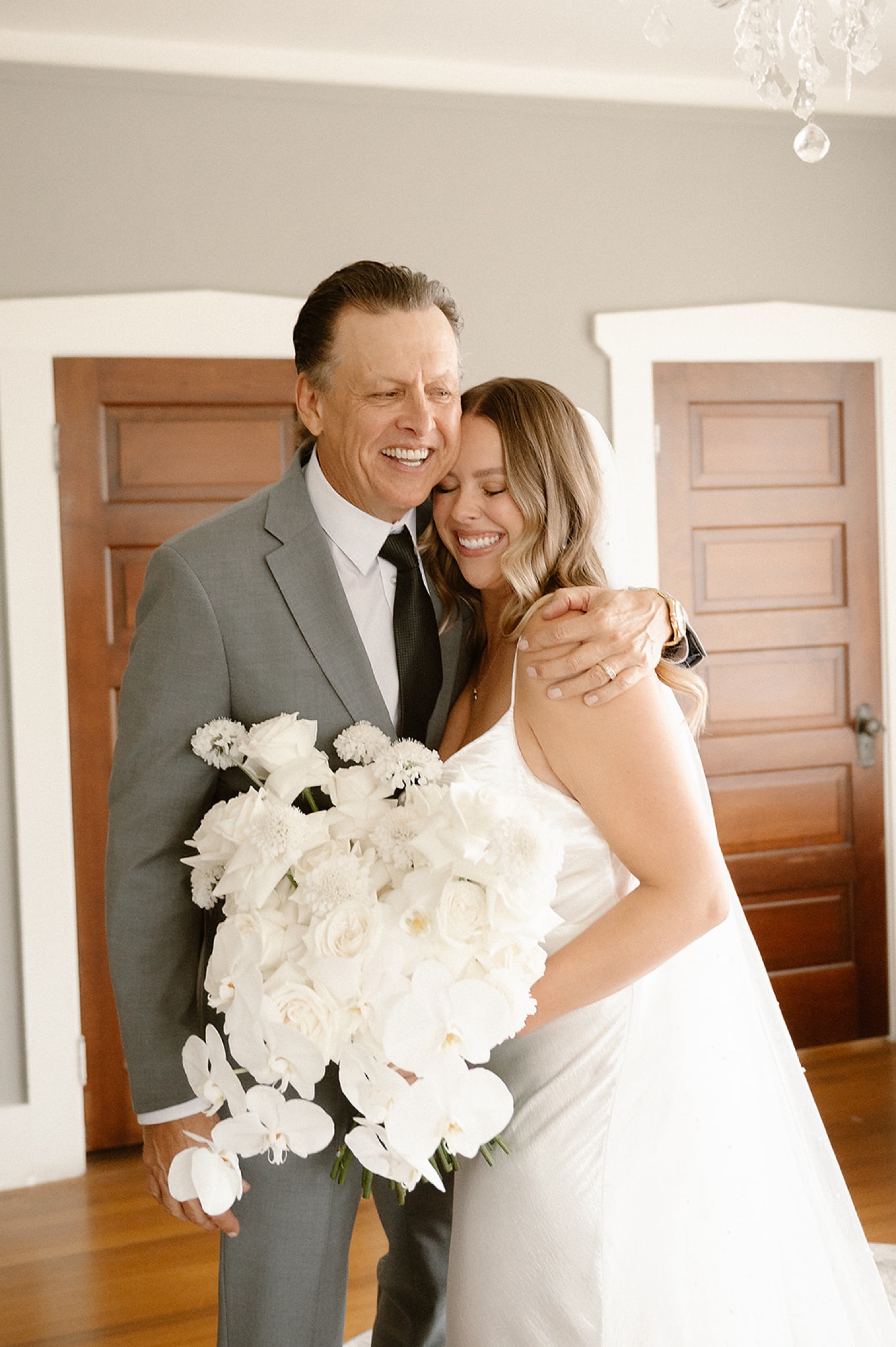 A bride hugging her father and smiling