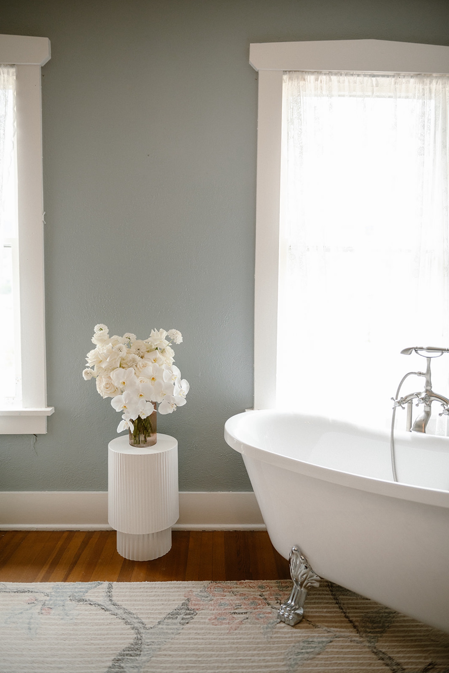 A bouquet sitting on a table next to a claw foot tub