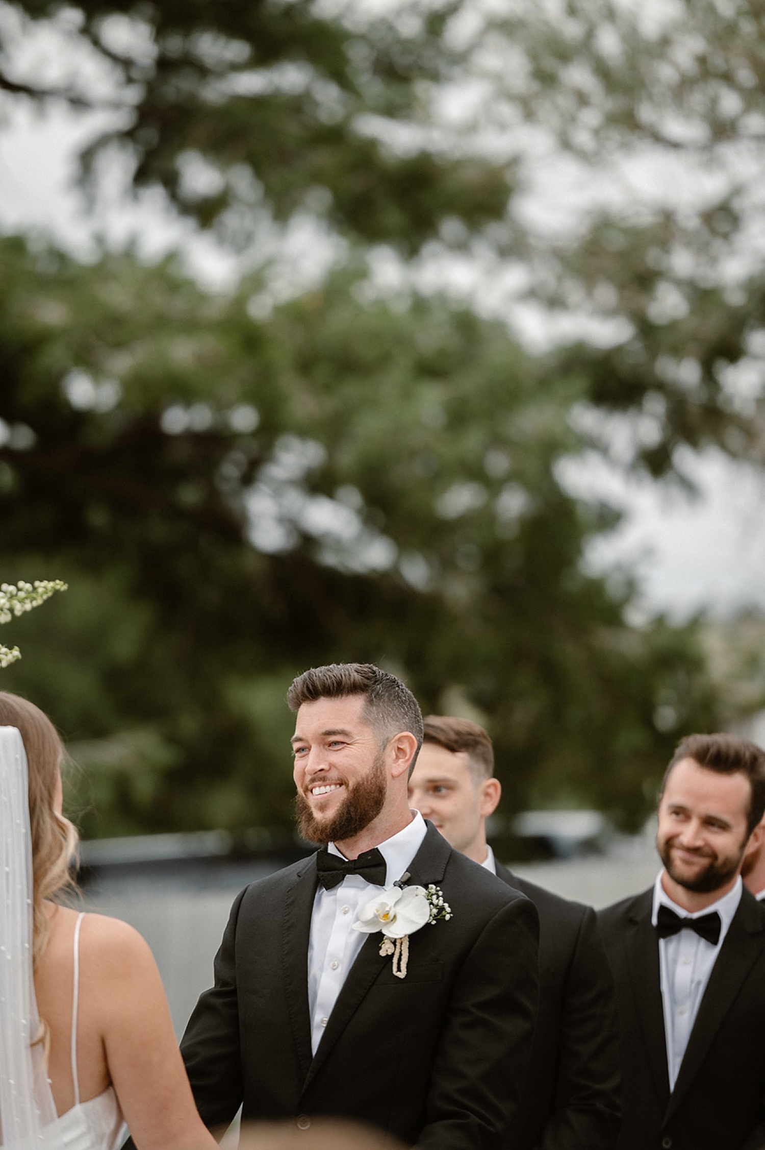 A groom smiles at his bride during the wedding ceremony