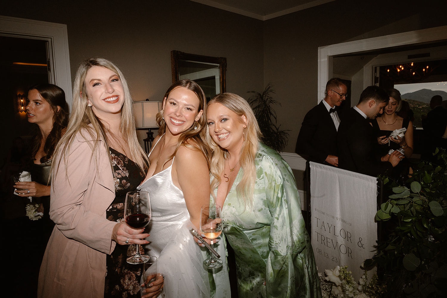 Wedding guests pose with the bride for portraits