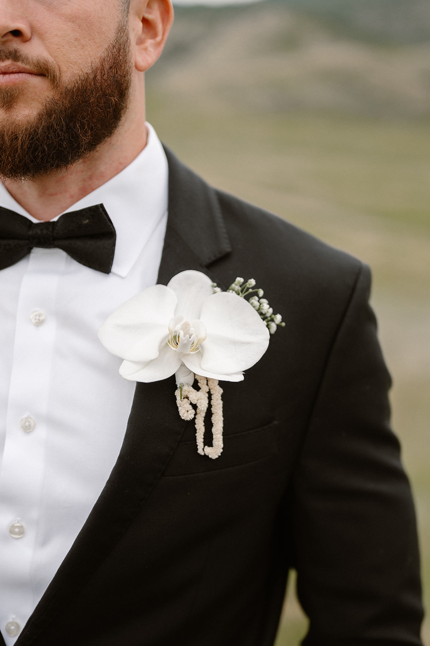 A detail of the groom's white boutonniere