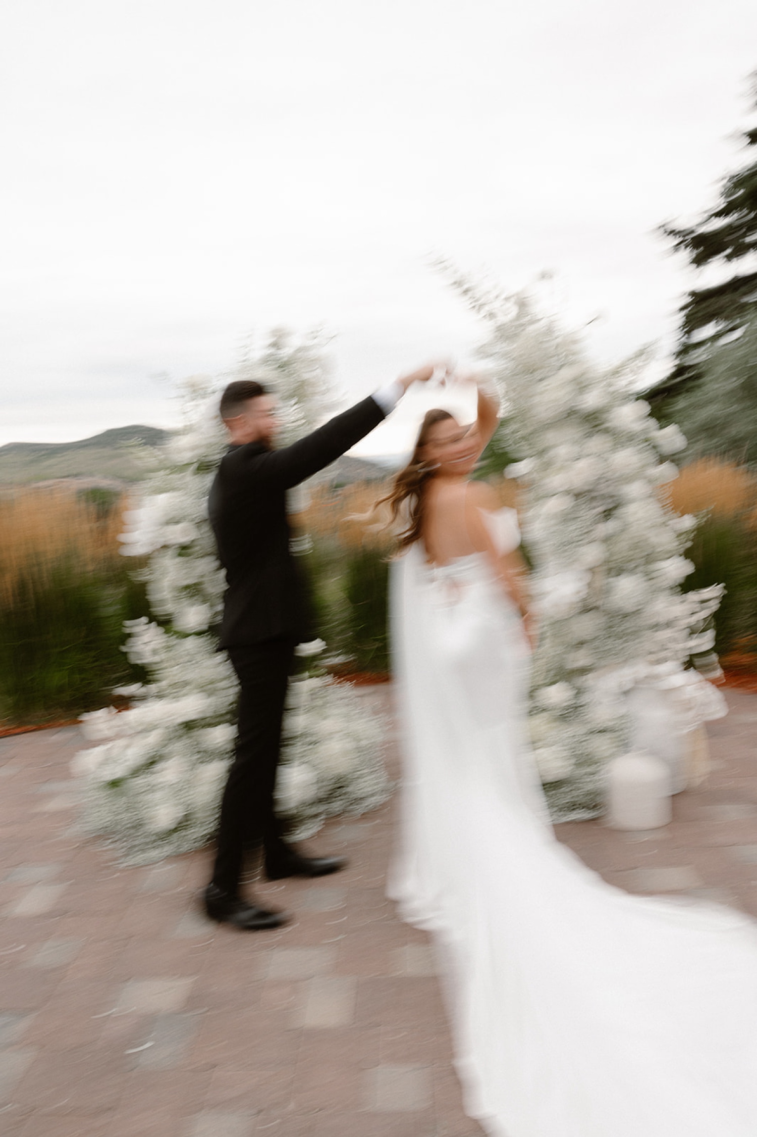 A blurry photo of a bride and groom dancing in front of their wedding arch at The Manor House