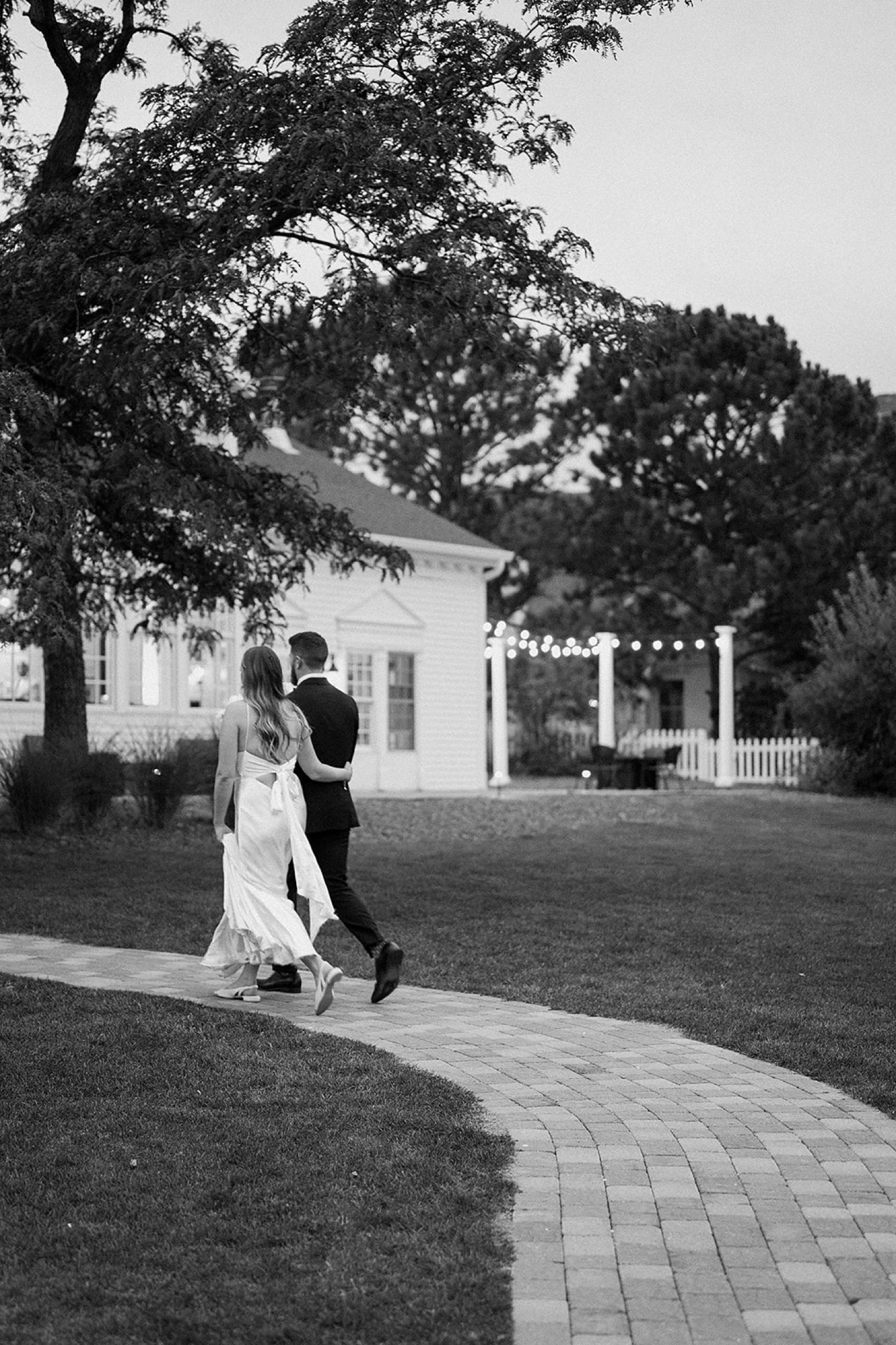 A bride and groom walk away from the camera