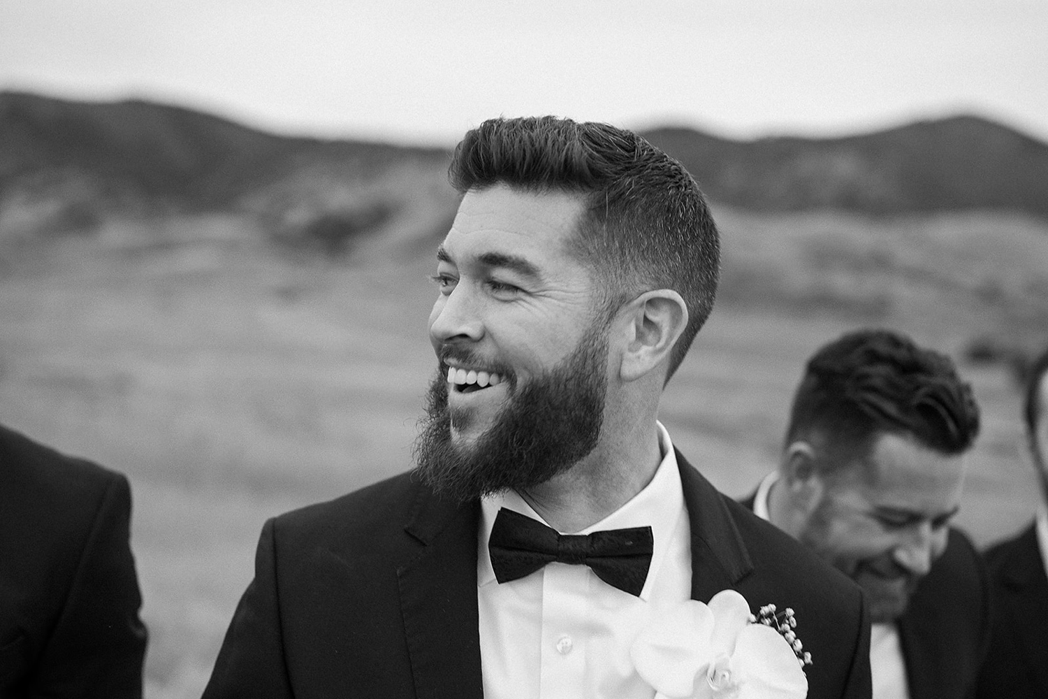 A groom laughs with his groomsmen