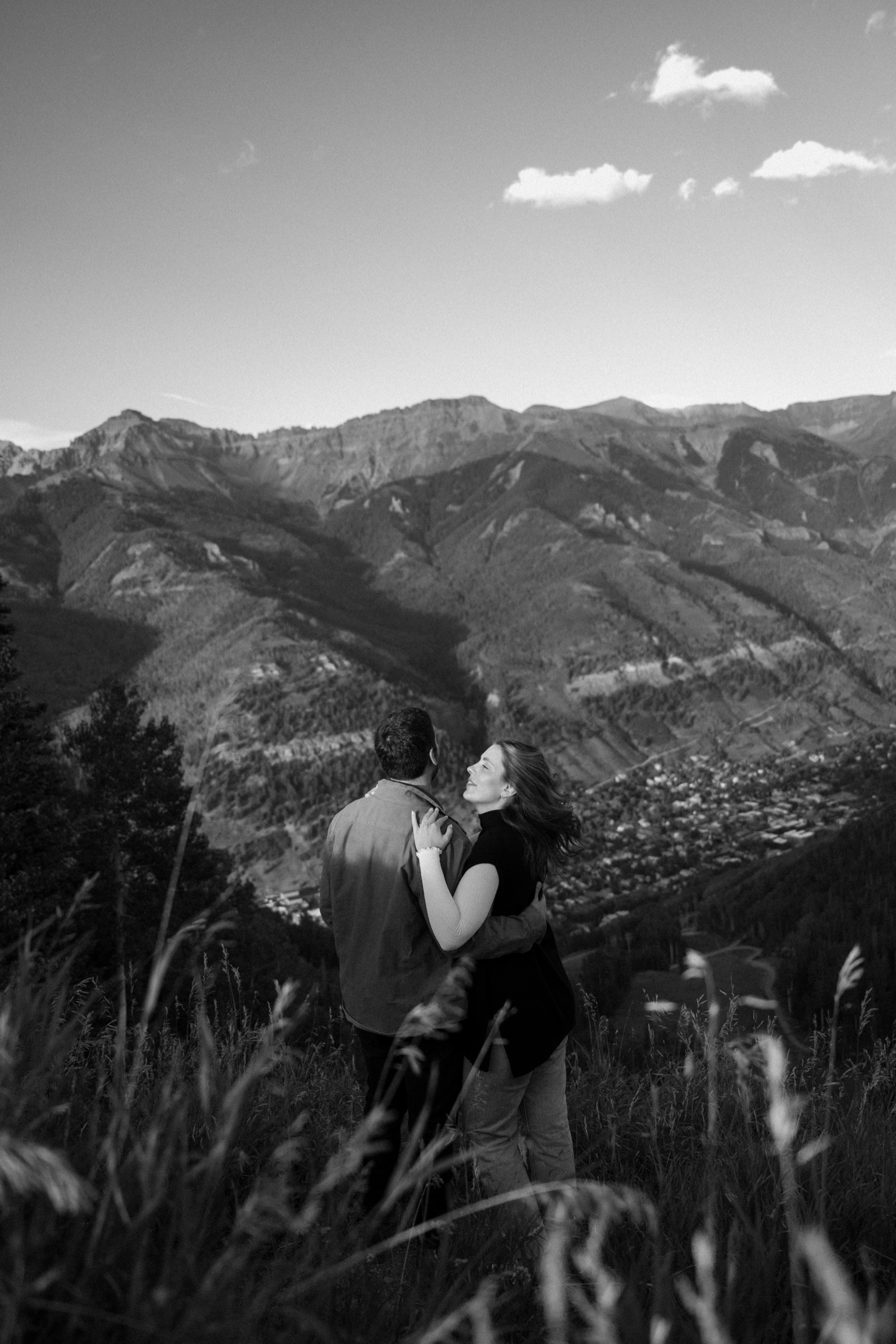 A couple poses for their Telluride engagement session at San Sophia Overlook at the Telluride ski resort. Photo by Durango wedding photographer Ashley Joyce