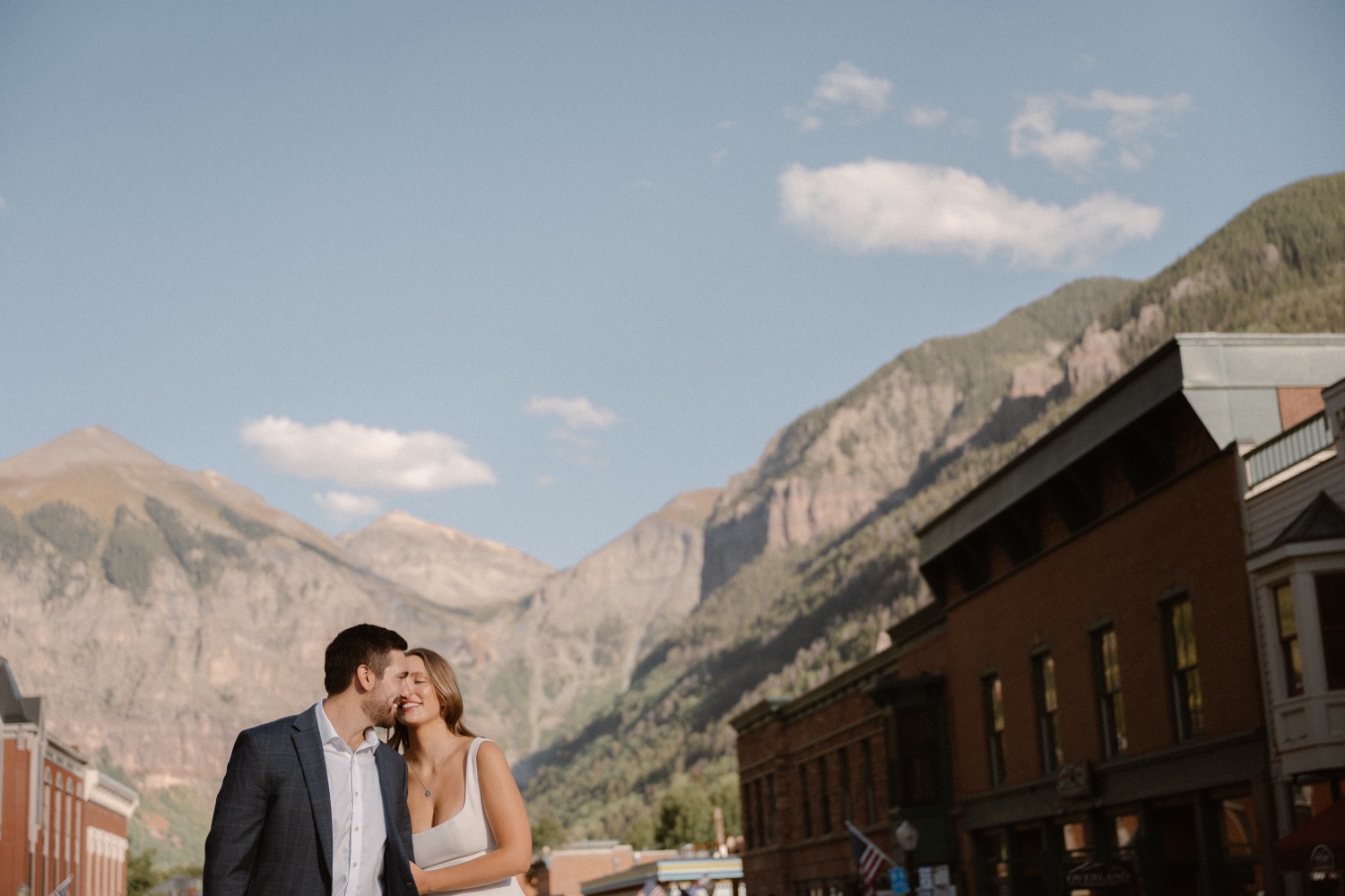 A couple poses for their Telluride engagement session in downtown Telluride, Colorado. Photo by Durango wedding photographer Ashley Joyce