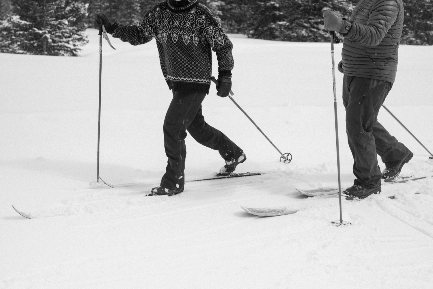 Beautiful snowy landscape of Montrose, Colorado, with couple on skis, showcasing the stunning setting for their winter engagement session