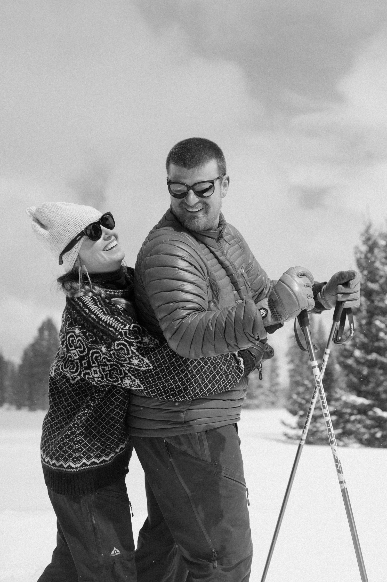 A couple sharing a warm, intimate moment while cross-country skiing in the snow during their winter engagement session in Montrose, Colorado.