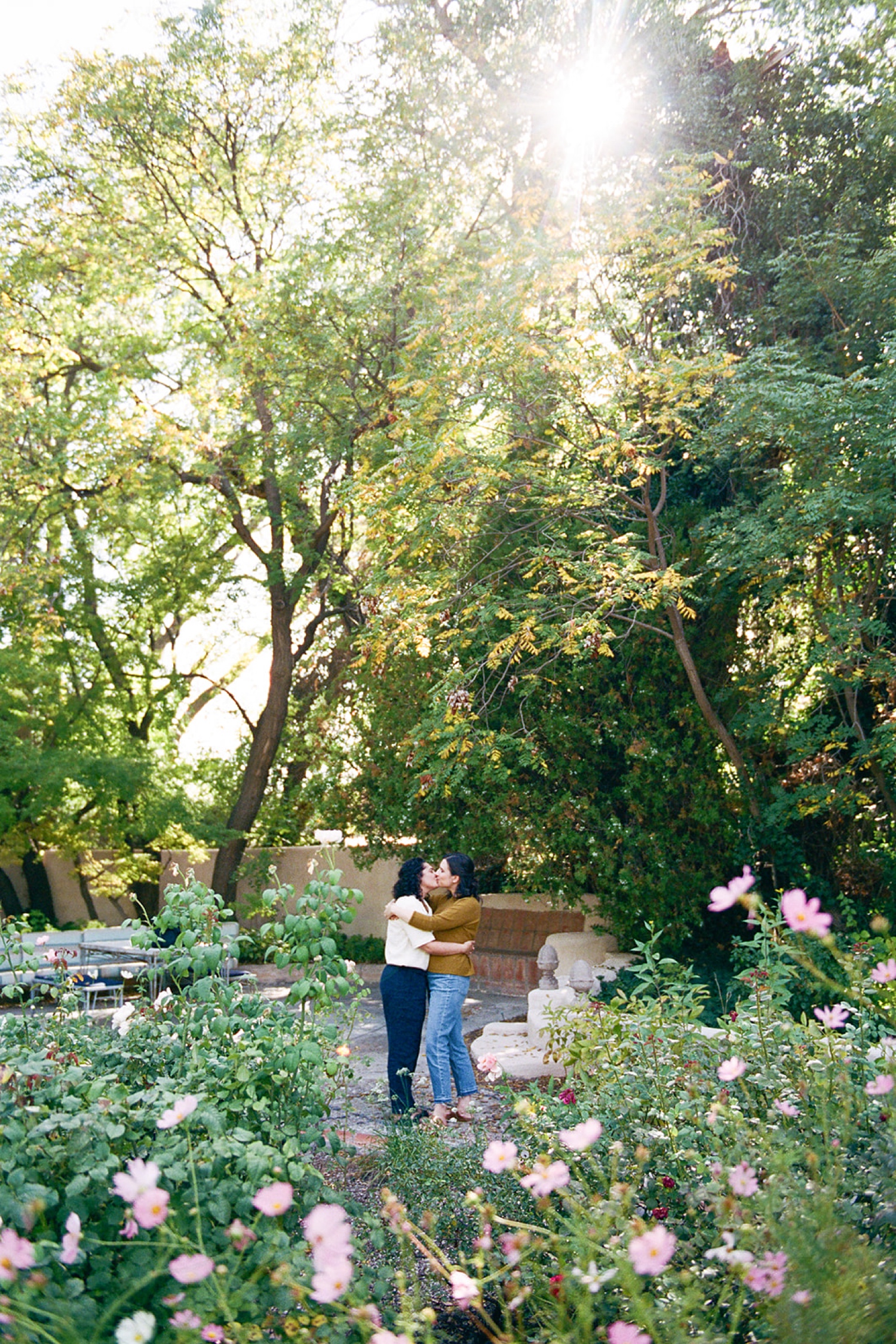 Romantic fall engagement session at Los Poblanos Historic Inn, couple embracing in front of the colorful foliage.