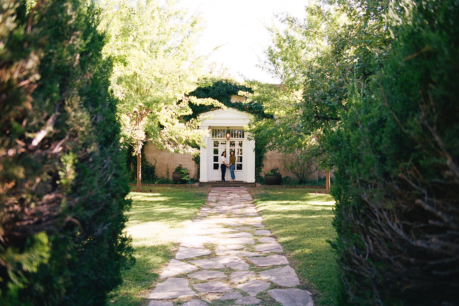 Romantic fall engagement session at Los Poblanos Historic Inn, couple embracing in front of the colorful foliage.