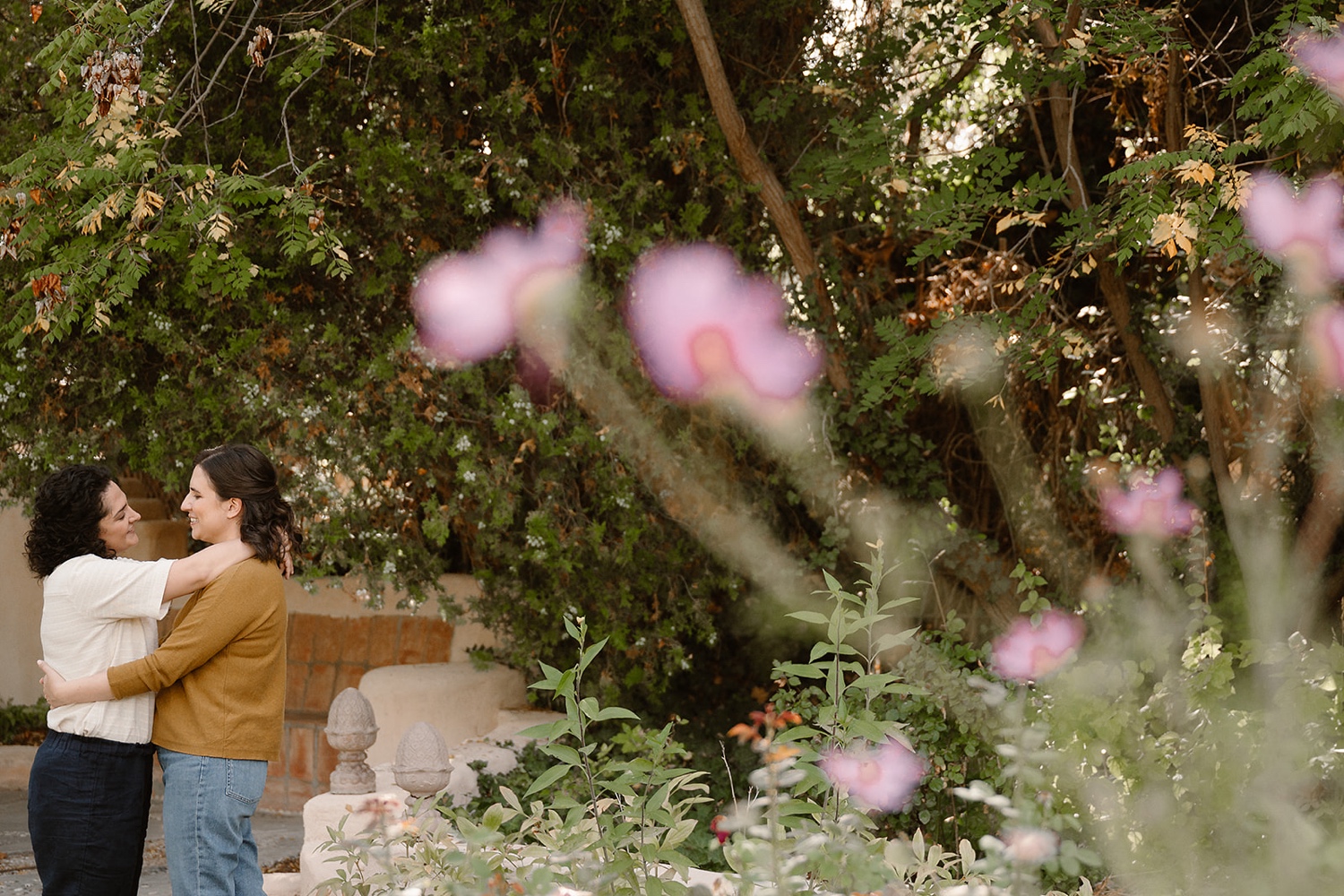 Romantic fall engagement session at Los Poblanos Historic Inn, couple embracing in front of the colorful foliage.