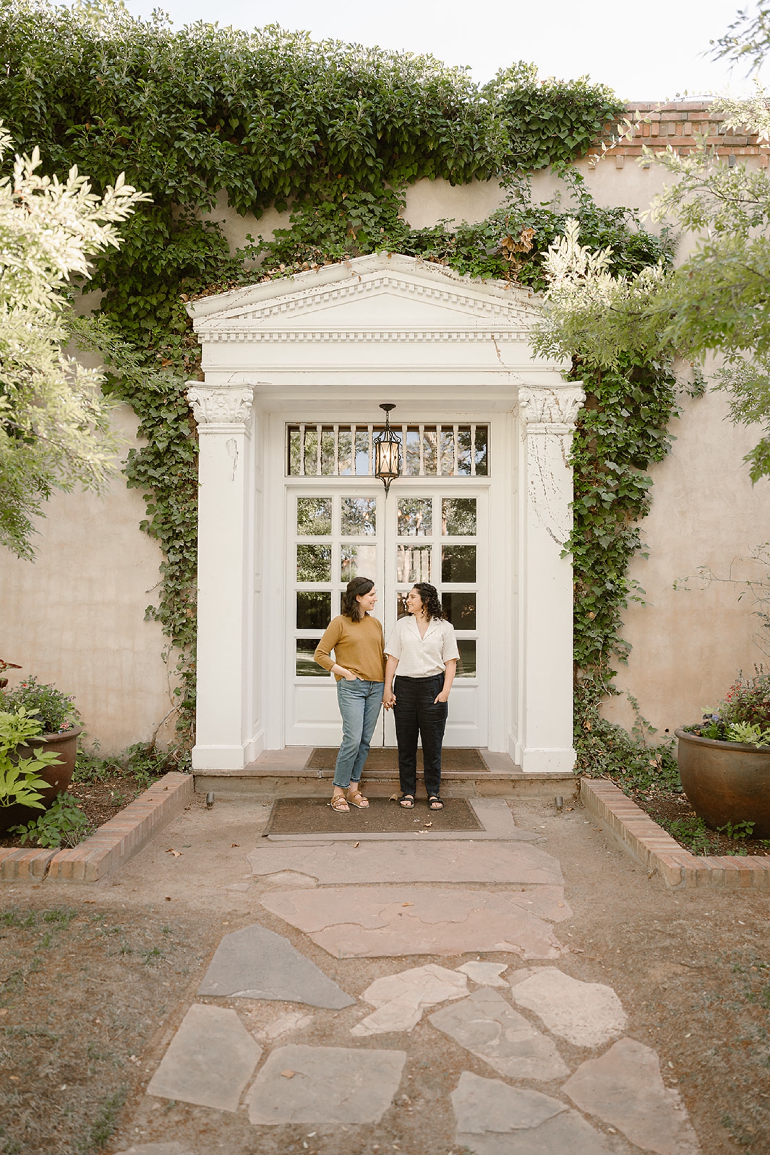 Romantic fall engagement session at Los Poblanos Historic Inn, couple embracing in front of the colorful foliage.