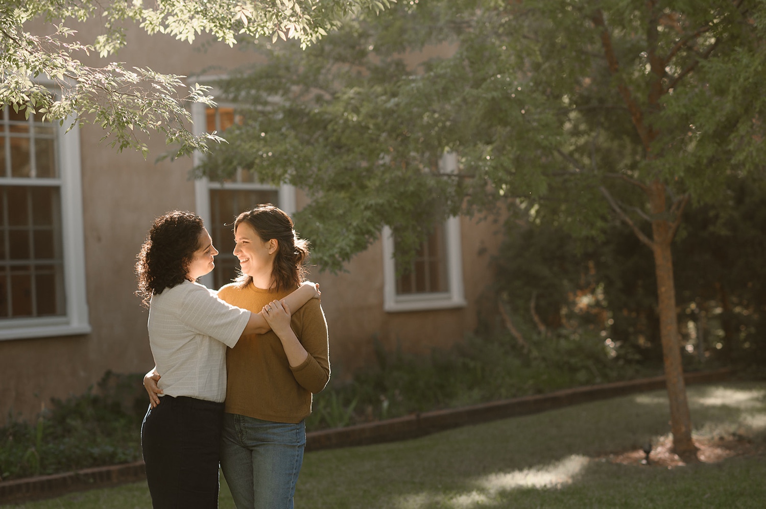 Romantic fall engagement session at Los Poblanos Historic Inn, couple embracing in front of the colorful foliage.