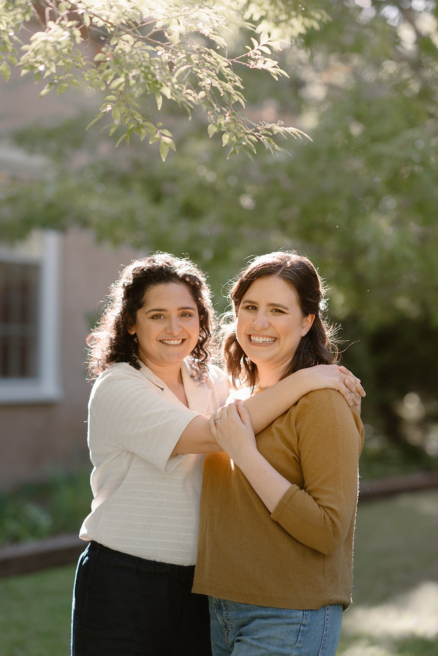 Romantic fall engagement session at Los Poblanos Historic Inn, couple embracing in front of the colorful foliage.