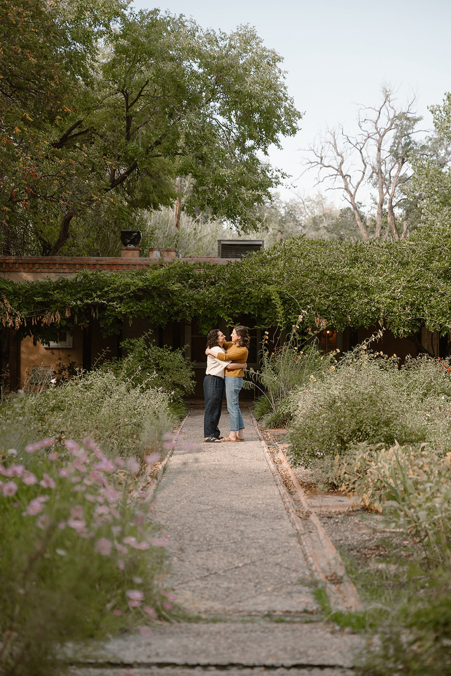 Engaged couple sharing a kiss in the fall at Los Poblanos Historic Inn, with colorful autumn trees creating a romantic atmosphere