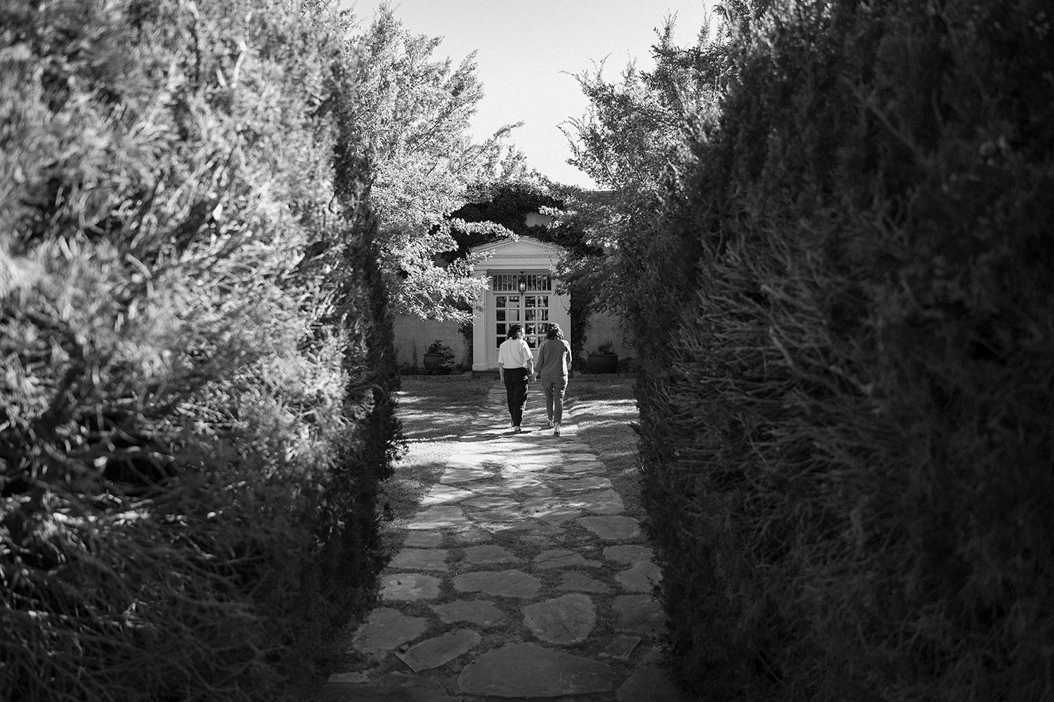 Romantic fall engagement session at Los Poblanos Historic Inn, couple embracing in front of the colorful foliage.